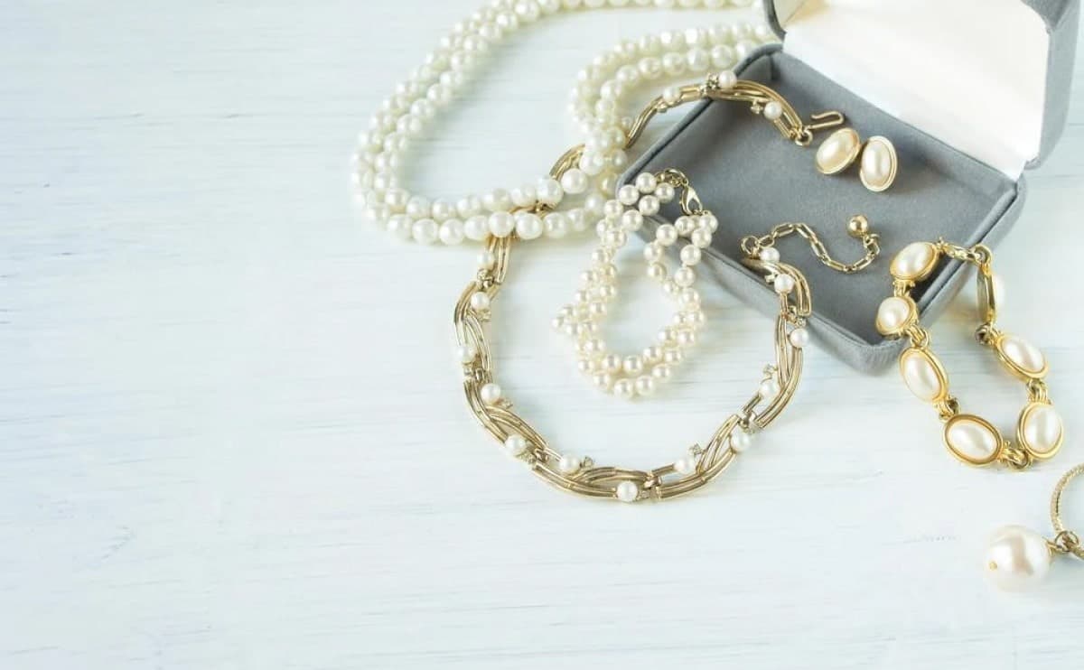 CARE — soft styled pearls and silver on linen, golden light